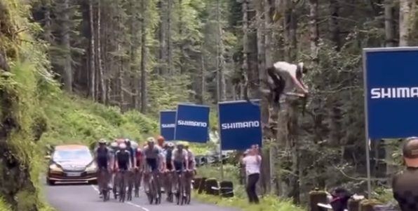 Tour 2024: Don’t try this at home! Mountainbiker doet bizarre stunt boven peloton