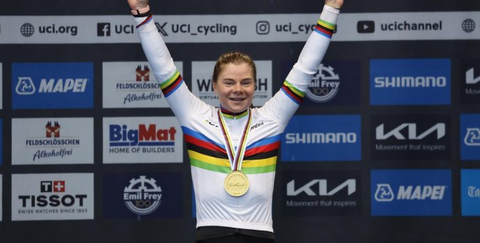 Zien! Feestende Lotte Kopecky in regenboogtrui al juichend onderuit op erepodium